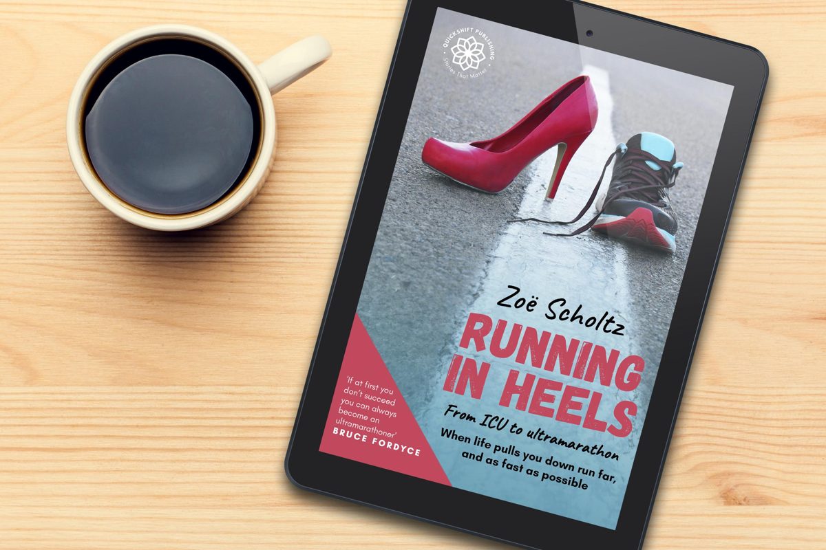 Running in Heels by Zoë Scholtz on a tablet beside a cup of coffee. The cover shows a red high heel and a running shoe on a white road line.